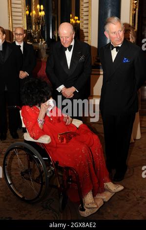 Prince Charles, Prince de Galles, Lord Rowe-Beddoe, président du Royal Welsh College (R) et actrice Dame Elizabeth Taylor, assis en fauteuil roulant, bavardent ensemble lors d'une soirée de gala au Royal Welsh College à Buckingham Palace à Londres, le 29 avril 2010. Banque D'Images