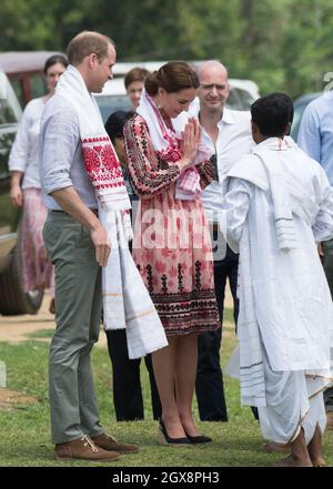 Le prince William, duc de Cambridge et Catherine, duchesse de Cambridge, portant une robe midi à imprimé rose de Topshop, rencontrent des villageois à Kaziranga, en Inde, le 13 avril 2016. Banque D'Images