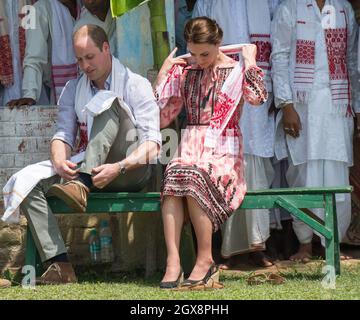 Le prince William, duc de Cambridge et Catherine, duchesse de Cambridge, portant une robe midi à imprimé rose de Topshop, rencontrent des villageois à Kaziranga, en Inde, le 13 avril 2016. Banque D'Images