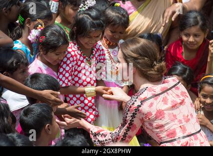 Le prince William, duc de Cambridge et Catherine, duchesse de Cambridge, portant une robe midi à imprimé rose de Topshop, rencontrent des villageois à Kaziranga, en Inde, le 13 avril 2016. Banque D'Images