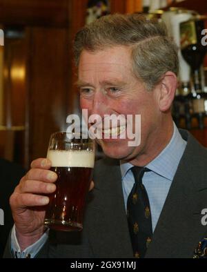 Le Prince Charles vous sert une pinte de bière lors de sa visite dans le village de Poundbury à Dorset.Le Prince a officiellement ouvert le pub poète lauréat, la première maison publique de Poundbury, et a rencontré des élèves de l'école de Bovington qui planteront des arbres dans la région pour marquer le Jubilé d'or de la Reine. Verre. Banque D'Images