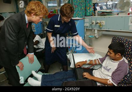 Le Prince Harry rencontre un patient de dialyse rénale, Michael Anderton, à droite, à l'hôpital Great Ormond Street, à Londres.Le Prince a passé la journée à visiter des organismes de bienfaisance et des causes qu'il entend appuyer. Banque D'Images