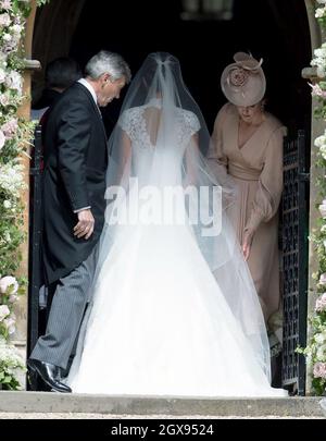 Catherine, Duchesse de Cambridge ajuste la robe de la mariée alors que Pippa Middleton arrive avec son père Michael Middleton pour son mariage à James Matthews à l'église St Marc, Englefield Green, le 20 mai 2017 Banque D'Images