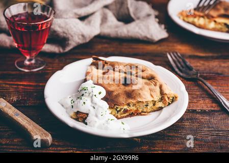 Tranche de tarte au chou avec sauce à la crème aigre sur blanc plaque Banque D'Images