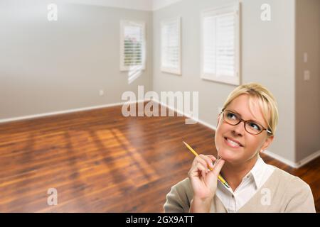 Femme avec crayon dans la chambre vide de la nouvelle maison. Banque D'Images