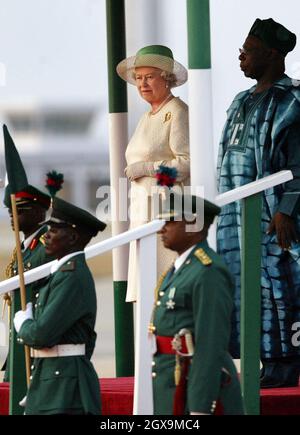 La reine Elizabeth de Grande-Bretagne et la présidente nigériane Olusegun Obasanjo, à droite, se tiennent pour des hymnes nationaux, à l'aéroport d'Abuja au Nigeria, au début de sa visite, au cours de laquelle elle assistera à la réunion des chefs de gouvernement du Commonwealth.Â©ANWAR HUSSEIN/ALLACTIONDIGITAL.COM PAS D'UTILISATION AU ROYAUME-UNI PENDANT 28 JOURS - PRÊT À L'EMPLOI LE 2 JANVIER 2004 Banque D'Images