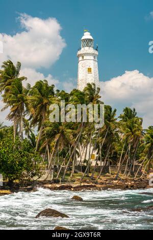 Phare blanc Dondra Head et palmiers tropicaux, près de Matara, le point le plus au sud du Sri Lanka. Banque D'Images