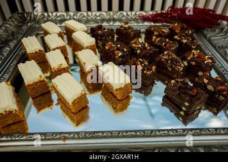 Tranches de biscuit aux noix, au cacao et au caramel à la table du buffet, servies sur le plateau argenté Banque D'Images