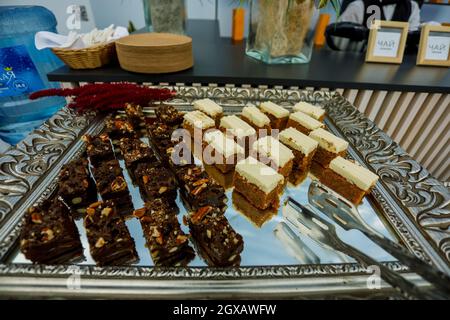 Tranches de biscuit aux noix, au cacao et au caramel à la table du buffet, servies sur le plateau argenté Banque D'Images