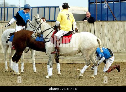 Le prince William se défait de son cheval en jouant contre son frère le prince Harry (en jaune) dans un match de polo de charité samedi 12 mars 2005 en aide aux victimes du tremblement de terre du lendemain de Noël dans l'extrême-Orient.Les princes ont pris sur le terrain sur les côtés opposés pour le match tenu au Longdole Polo Club à Birdlip, Gloucestershire.Le prince Harry faisait partie de l'équipe gagnante qui a reçu le trophée Hayley Charity de Louise Knights.Heureusement, le prince William est sorti sans douleur.Anwar Hussein/allactiondigital.com Banque D'Images