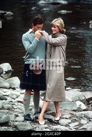 Le prince Charles, prince de Galles, embrasse Diana, princesse de Galles au moment où ils posent par la rivière Dee pour la presse lors de leur lune de miel à Balmoral en Écosse en août 1981. Banque D'Images