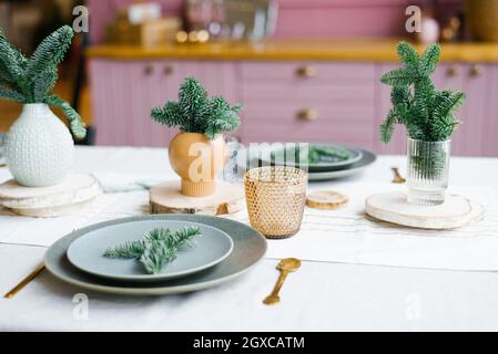 Des branches ou des pins de sapin frais dans un vase en céramique, un vase sur la table de cuisine en décoration pour Noël et nouvel an. Banque D'Images