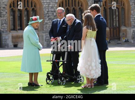 La reine Elizabeth II (à l'aide de l'épée qui appartenait à son père, le roi George VI) confère l'honneur de chevalier au capitaine Sir Thomas Moore, âgé de 100 ans, avant de lui présenter l'insigne du baccalauréat lors d'une cérémonie d'investiture au château de Windsor, le 17 juillet 2020.Le capitaine Tom Moore a amassé plus de 32 millions de livres sterling pour le NHS pendant la pandémie du coronavirus. Banque D'Images