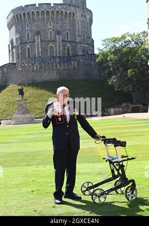 La reine Elizabeth II (à l'aide de l'épée qui appartenait à son père, le roi George VI) confère l'honneur de chevalier au capitaine Sir Thomas Moore, âgé de 100 ans, avant de lui présenter l'insigne du baccalauréat lors d'une cérémonie d'investiture au château de Windsor, le 17 juillet 2020.Le capitaine Tom Moore a amassé plus de 32 millions de livres sterling pour le NHS pendant la pandémie du coronavirus. Banque D'Images