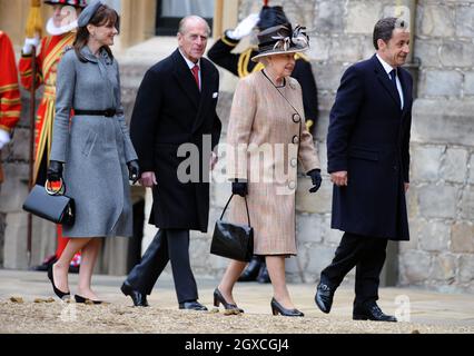 La reine Elizabeth II, le président français Nicolas Sarkozy, Carla Bruni-Sarkozy et le prince Philip, duc d'Édimbourg inspectent les gardes lors d'une cérémonie d'accueil au château de Windsor.Le président Nicolas Sarkozy et Carla Bruni-Sarkozy sont en visite d'État de deux jours au Royaume-Uni. Banque D'Images