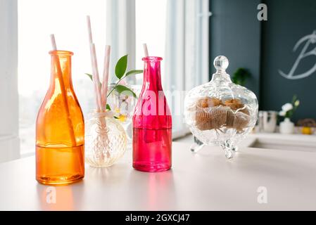 Bouteilles en verre colorées avec pailles en papier pour boissons ou cocktails Banque D'Images