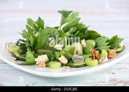 Salade de feuilles de céleri et de tiges avec tranches de concombre frais, fromage bleu, noix écrasées. Banque D'Images