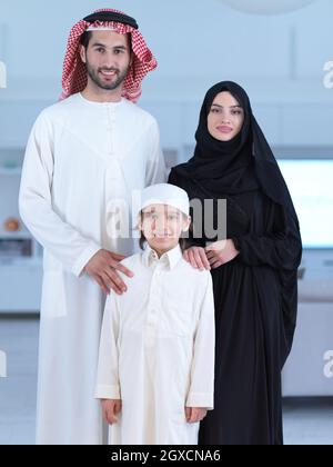 Portrait de jeunes heureux parents musulmans arabes couple avec fils dans des vêtements traditionnels passer le temps ensemble pendant le mois du Ramadan à la maison Banque D'Images