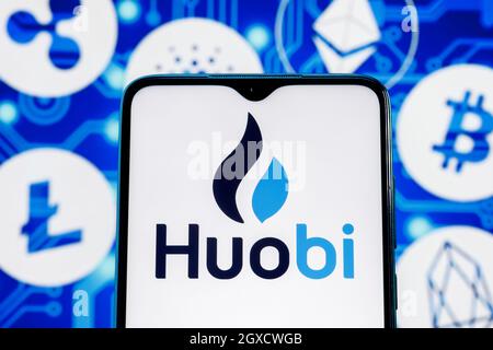 Huobi est un échange de crypto-monnaies. Logo Huobi sur l'écran du smartphone sur l'arrière-plan des principales crypto-monnaies. Banque D'Images