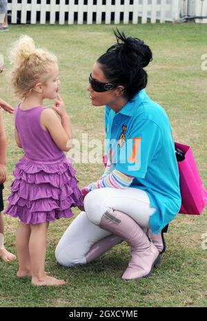 Katie Price se plie pour parler à sa fille, la princesse Tiaamii, à la coupe du monde Asprey au club de polo Hurtwood Park à Surrey, le 17 juillet 2010. Banque D'Images