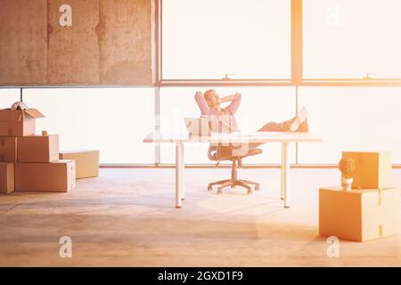Young businessman Taking a break sur chantier lors de la vérification de documents et de travail de l'entreprise à l'aide d'un ordinateur portable avec la lumière du soleil par Banque D'Images