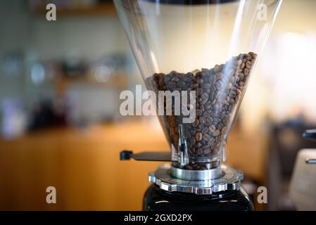 Grains de café dans un moulin à café pour les machines à café pour les clients Banque D'Images