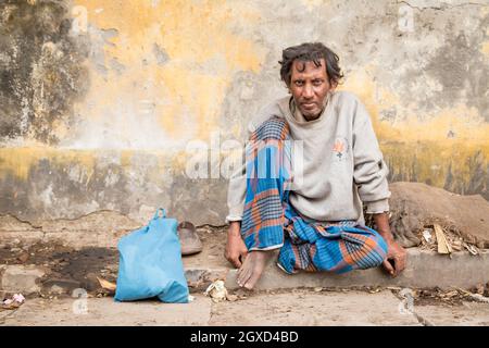 INDE, BANGLADESH - 6 DÉCEMBRE 2015 : homme ethnique mature en vêtements traditionnels assis dans la rue Banque D'Images