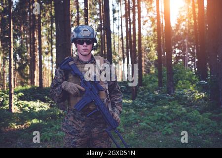 portrait de soldat avec équipement tactique de protection de l'armée et arme dedans forêt Banque D'Images