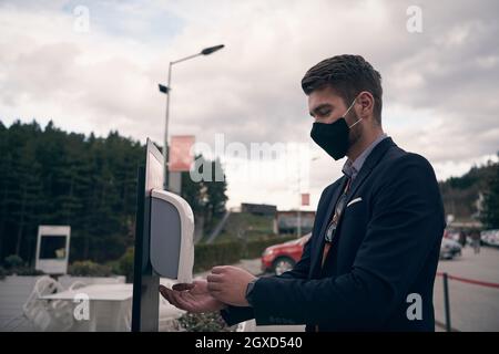 Les clients du restaurant se lavant les mains à l'aide d'un gel désinfectant automatique. Prévention des coronavirus dans un restaurant de café pendant la corona viru Banque D'Images