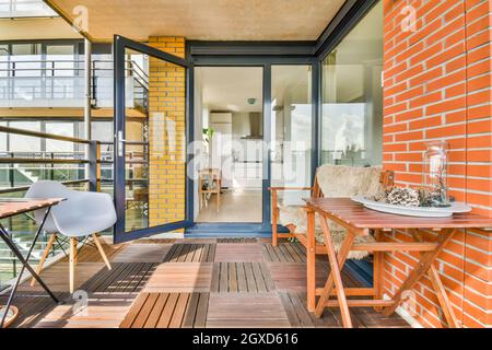 Plateau avec vase et cônes de pin sur la table, entre le mur de briques et le fauteuil sur la terrasse Banque D'Images