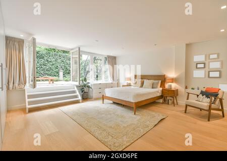 Intérieur d'une chambre spacieuse et lumineuse lit confortable et entrée sur terrasse dans un cottage moderne Banque D'Images