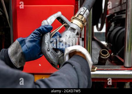 Lippstadt, Allemagne. 05e octobre 2021. Un employé tire le flexible d'alimentation en huile de chauffage vers un client hors du camion-citerne. Les consommateurs peuvent s’attendre à une forte hausse des coûts de chauffage cette année en raison de la forte demande mondiale de pétrole brut. Il sera encore plus cher en 2021 dans les maisons avec chauffage au pétrole, où les coûts devraient augmenter de 44 pour cent - après avoir chuté de 27 pour cent l'année précédente. Credit: David Inderlied/dpa/Alay Live News Banque D'Images