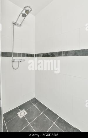 Intérieur de la salle de bains avec cabine de douche vide avec murs carrelés blancs dans l'appartement Banque D'Images