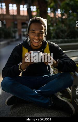 Vue latérale de la culture ethnique masculine maître peignant des brins de la cliente féminine avant la teinture en technique de mise en balles Banque D'Images