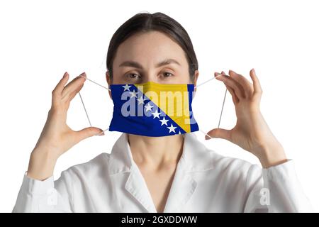 Respirateur avec drapeau de Bosnie-Herzégovine le docteur met sur le masque médical isolé sur fond blanc. Banque D'Images