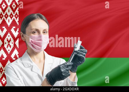 La jeune fille prépare la vaccination contre le fond du drapeau de la Biélorussie. Concept de vaccination Bélarus. Banque D'Images