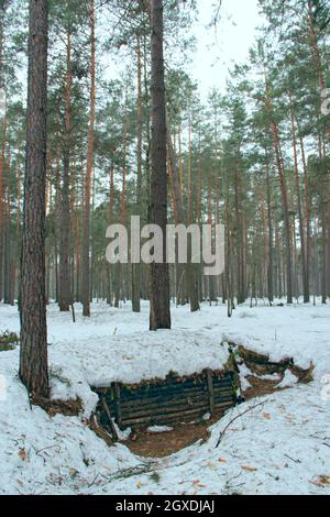 Tranchées partisanes pendant la Seconde Guerre mondiale en Ukraine. Tranchées partisanes dans la forêt d'hiver. Tranchées pendant la guerre entre l'Allemagne fasciste et le Sol Banque D'Images