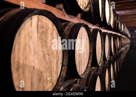 Des rangées de fûts de cave à vin anciennes sur des étagères Banque D'Images