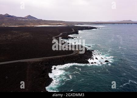 Vue de drone de la mer mousseuse contre la chaussée incurvée et les montagnes avec Hervideros à Yaiza Lanzarote îles Canaries Espagne Banque D'Images