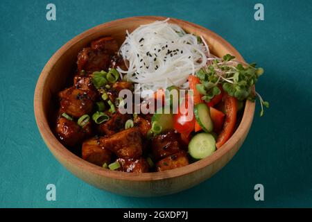 Tofu frit avec des nouilles de cristal de riz dans un bol en bois. Banque D'Images