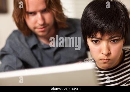 Jeune homme et femme diligent utilisant un ordinateur portable ensemble. Banque D'Images