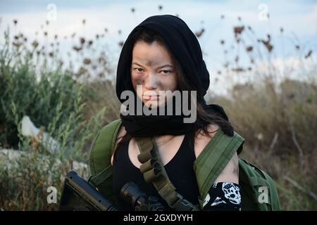 Une femme soldat de la milice dans un désert post-apocalyptique. Combats urbains et terres désertiques Banque D'Images