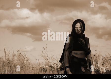 Une femme soldat de la milice dans un désert post-apocalyptique. Combats urbains et terres désertiques Banque D'Images