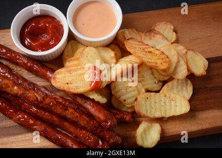 Saucisses grillées avec frites maison et sauce, ketchup Banque D'Images