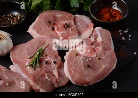 Sur une table, faire cuire de la viande fraîche d'ossobuco avec des épices et des herbes. Ingrédients pour ragoût italien Banque D'Images