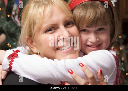 La mère et l'enfant dans ses bras devant un arbre de Noël. Banque D'Images