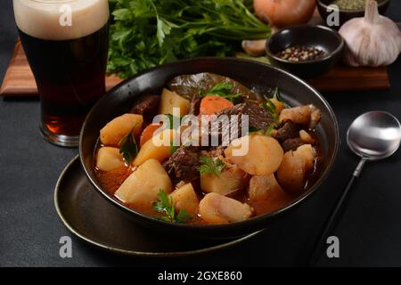 Ragoût irlandais à base de bœuf, de pommes de terre, de carottes et d'herbes. Plat de jour traditionnel de Saint-Patrick, cuit dans une bière Guinness foncée Banque D'Images