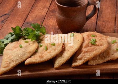 Chebureau - tourtes frites avec viande et oignons. La cuisine caucasienne est une patty faite de pâte sans levain fine avec de l'agneau farci et des assaisonnements épicés. Banque D'Images