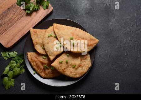 Chebureau - tourtes frites avec viande et oignons. La cuisine caucasienne est une patty faite de pâte sans levain fine avec de l'agneau farci et des assaisonnements épicés. Banque D'Images