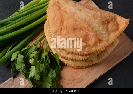 Chebureau - tourtes frites avec viande et oignons. La cuisine caucasienne est une patty faite de pâte sans levain fine avec de l'agneau farci et des assaisonnements épicés. Banque D'Images